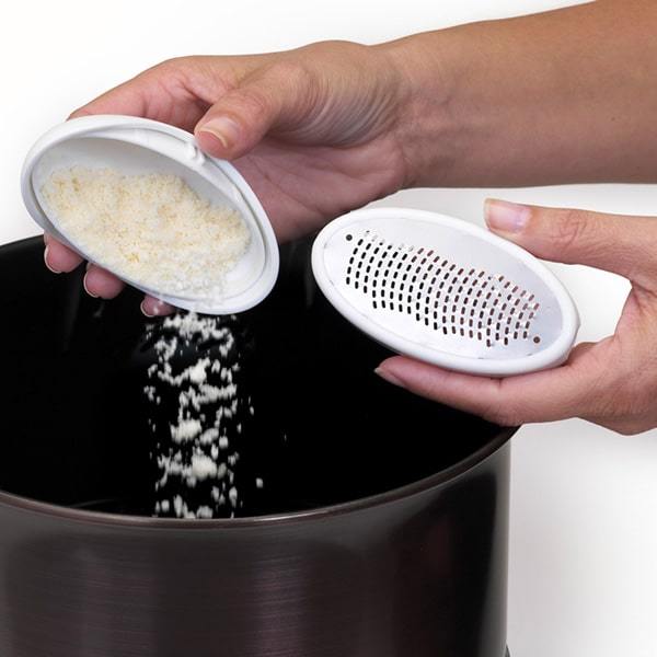 Close up of someone emptying shavings out of PedEgg over a garbage bin