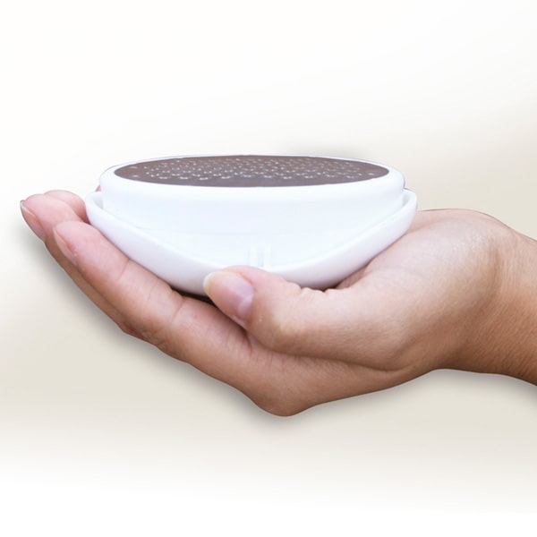 Close up of someone holding a PedEgg upside down with the grate side up isolated on a white background