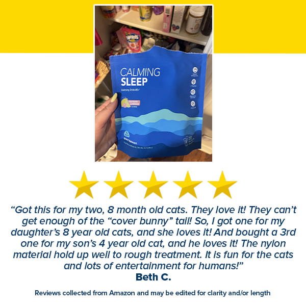 A hand holds a blue Calming Sleep (Includes 30 Packs) cat toy package. Below are five yellow stars and a review praising the Calming Sleep toy’s durability and its appeal to multiple cats and a child. Shelves with assorted items are visible in the background.