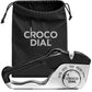 The Croco Dial multi-stage knife sharpener with a black handle and silver base, positioned in front of a black drawstring storage bag as part of a sharpening system.