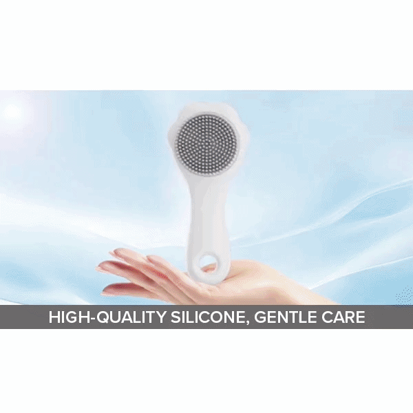 A hand holds the Cat Waterless Shampoo with Brush, featuring a white silicone bristle head. Set against a soft, cloudy light blue background. The caption below reads: “HIGH-QUALITY SILICONE, GENTLE CARE.”.