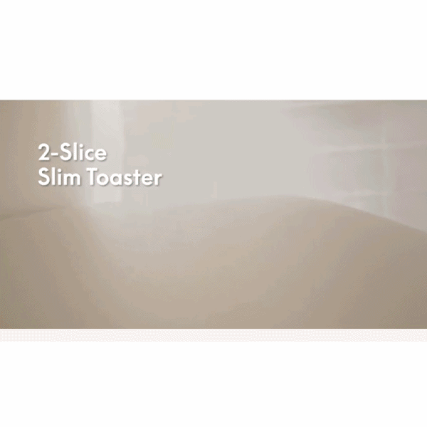 A shiny silver Slim Toaster Fits Anywhere with extra-wide slots pops out two toasted slices of bread in a bright kitchen. Text reads Slim Toaster Fits Anywhere.