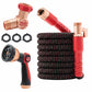 The Pocket Hose Ballistic, a coiled black and red expandable garden hose with brass connectors, a red adjustable spray nozzle, Y-shaped brass splitter, and three black rubber washers is shown on a white background.