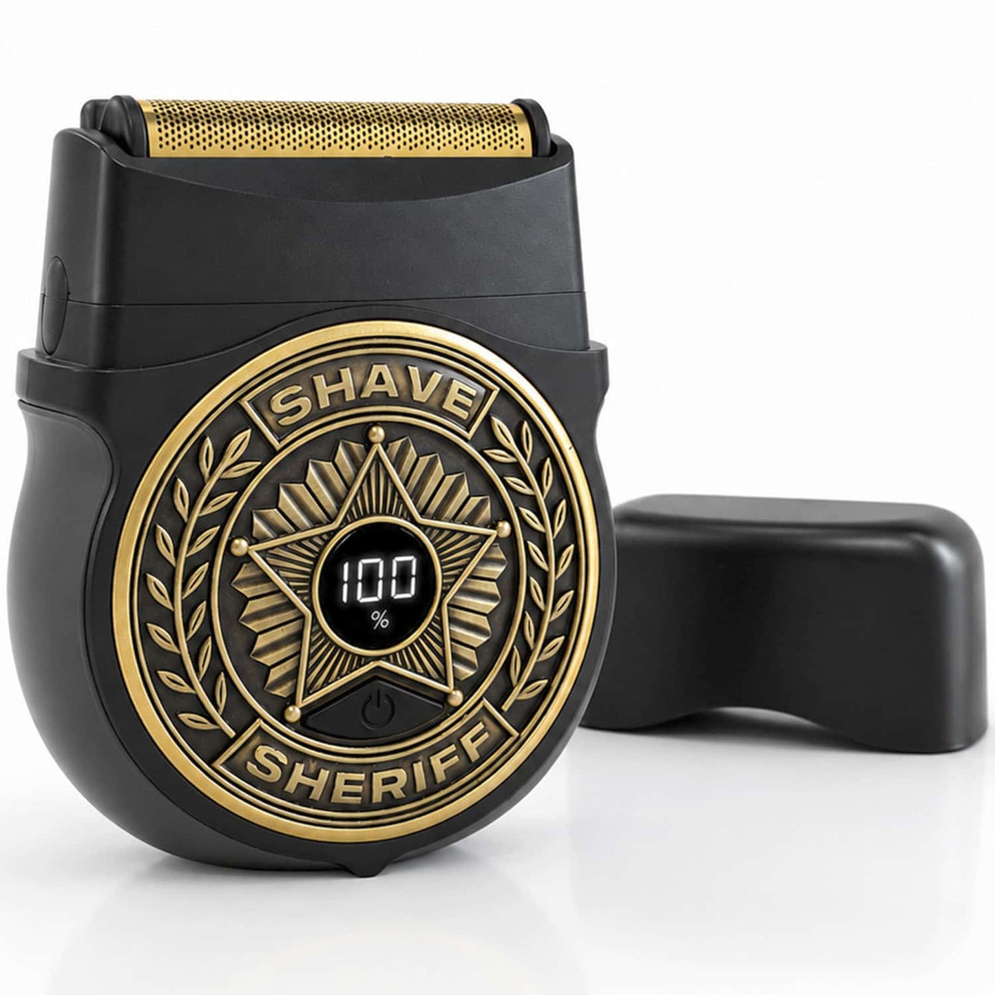 The Shave Sheriff is a compact electric razor featuring a black titanium blade, a gold sheriff badge design, and a digital display showing 100%. It comes with a black protective cap, displayed next to it on a white background.