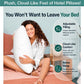 A woman sits on a bed smiling and hugging a large white Adjustable Height Pillow, with text highlighting its adjustable filling, cloud-like comfort, and better sleep benefits for personalized comfort.