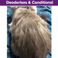 A fluffy gray cat lies on a blue patterned blanket, back to the camera. A purple banner reads, Deodorizes & Conditions!—perfect for use with Cat Waterless Shampoo with Brush.