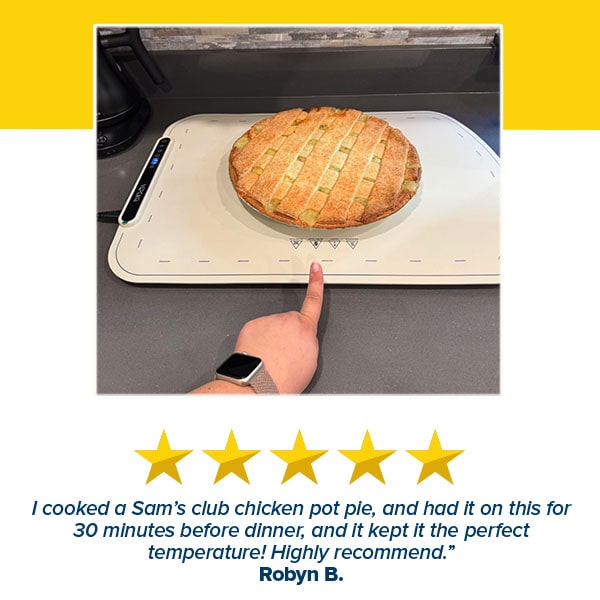 A hand points to a chicken pot pie resting on the Electric Food Warming Mat, made with food-grade silicone. Below, a five-star review praises the mat for keeping food at the perfect temperature.