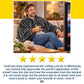 A man sits on a sofa wearing a gray Electric Heated Shawl and holding a remote control, accompanied by a five-star rating and a customer review.