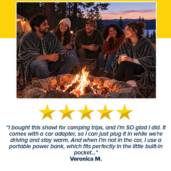 Four people sit on camping chairs around a fire pit at dusk, three of whom are wrapped in dark gray Electric Heated Shawl blankets.