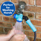 A person washes their hands using the blue Garden Hose Faucet Connector With Tap, attached to an outdoor tap on a brick wall. A circular label reads “Perfect for Washing Hands” as water flows from the connector onto their hands.