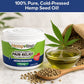 A container of Hempvana Hemorrhoid, a bowl of oil, hemp seeds, and a hemp leaf on a table, with the text "100% Pure, Cold-Pressed Hemp Seed Oil!" at the top—perfect for those seeking natural comfort with soothing hemp seed oil benefits for relief similar to lidocaine hemorrhoid treatments.