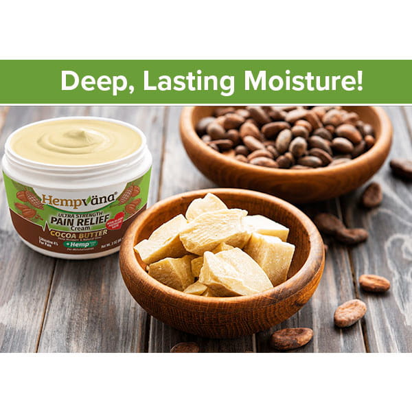 A jar of Hempvana Cocoa Butter, enriched with hemp seed oil, sits beside bowls of cocoa beans and cocoa butter pieces on a wooden table. Text above reads: Deep, Lasting Moisture!.