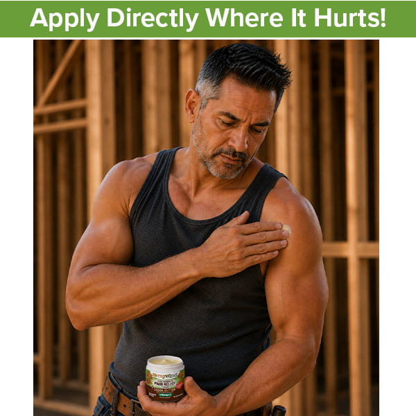 A man in a black tank top applies Hempvana Cocoa Butter to his shoulder. Wooden beams are in the background. A green banner above reads, Apply Directly Where It Hurts!.