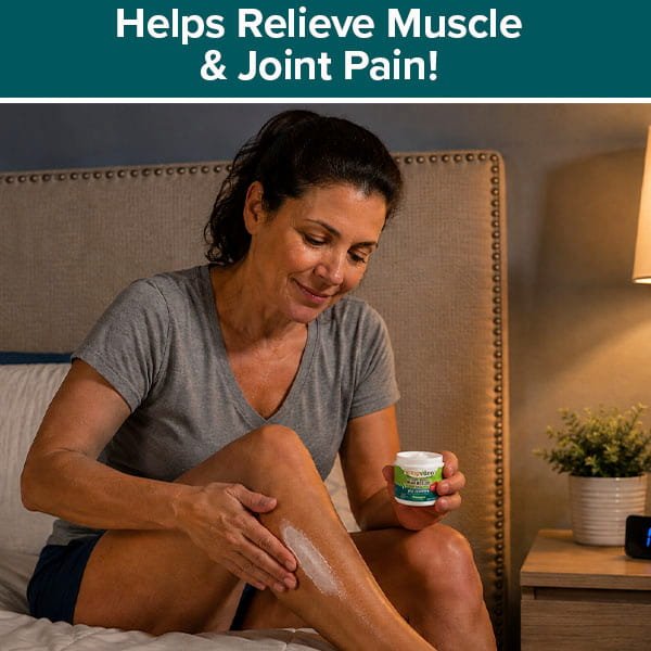 A woman sits on a bed applying Hempvana Leg Cramps to her leg. Text above reads, Helps Relieve Muscle & Joint Pain! A nightstand with a lamp and plant is beside her.