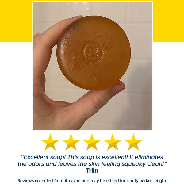 A hand holds a round, translucent amber Kaori Soap Bar for Old People Smell with an embossed logo above five yellow stars and a positive customer review.