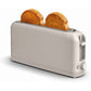 The Slim Toaster Fits Anywhere is a wide, white toaster with an extra-wide slot for thicker breads. It has two slices of toasted bread inside and features a dial and lever on the right side, all in a modern, minimalist design.