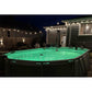 A backyard above-ground pool glows at night with Solar Pool Lights for Inground & Above Ground Pool, while string lights hang on the wooden fence and house. Cozy patio furniture and a hammock complete the relaxing scene.