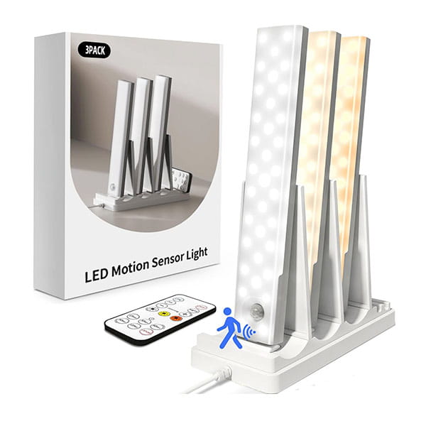 The 3-Pack Under Cabinet Lighting With Charging Station features three white motion sensor lights on a charging base, complete with remote control and packaging labeled 3PACK LED Motion Sensor Light.