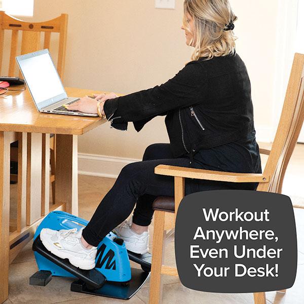 Woman sitting at desk using laptop and a Blu Tiger underneath the desk. Text says "Workout Anywhere, Even Under Your Desk!"