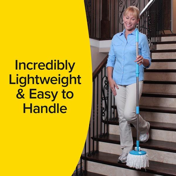 Woman descending stairs harrying Spin Mop in one hand