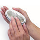 Close up of woman holding a PedEgg with the grate side up and they are touching it with their fingers