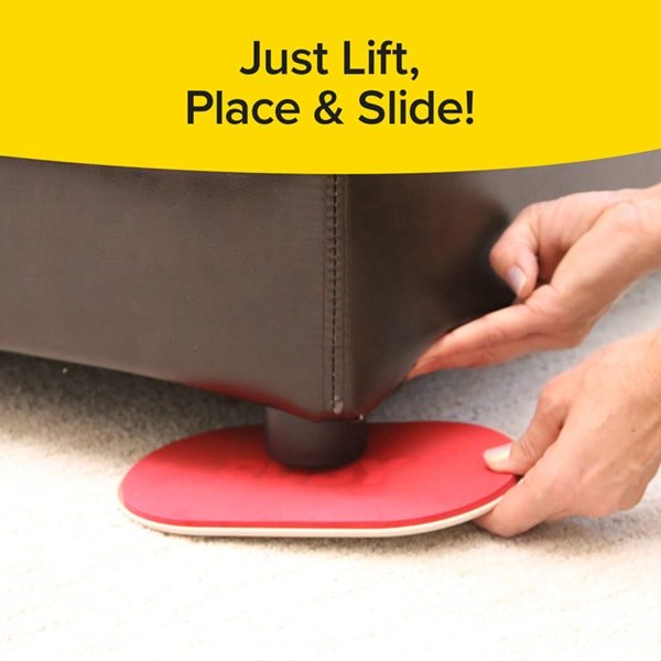 image of the bottom corner of a couch with a  hand placing a red ruby mover unit  under the couch leg  on top of a rug. there is black text over a yellow banner on top of the image with text that reads "just lift, place & slide!"