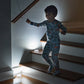small child going down some stairs and an Atomic Beam Tapligjht is on each step lit up