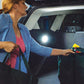 Woman getting grocery bags from trunk and an Atomic Beam Taplight is lit up on the interior of the trunk