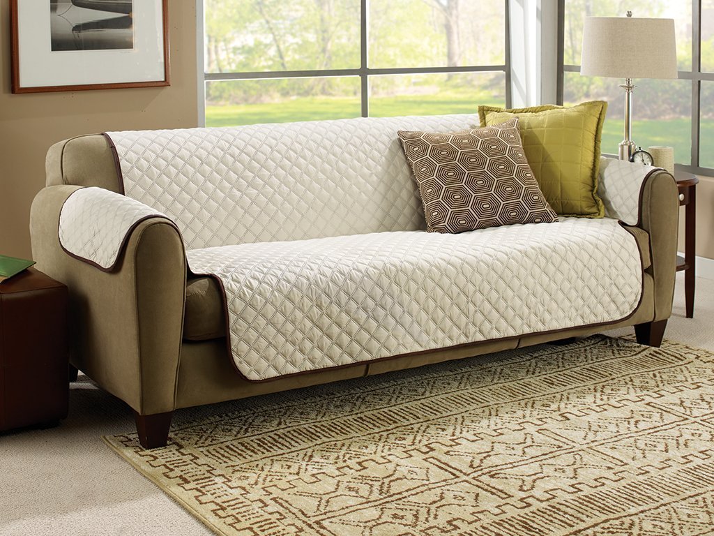 Beige Couch Coat laid on a couch with two pillows on it